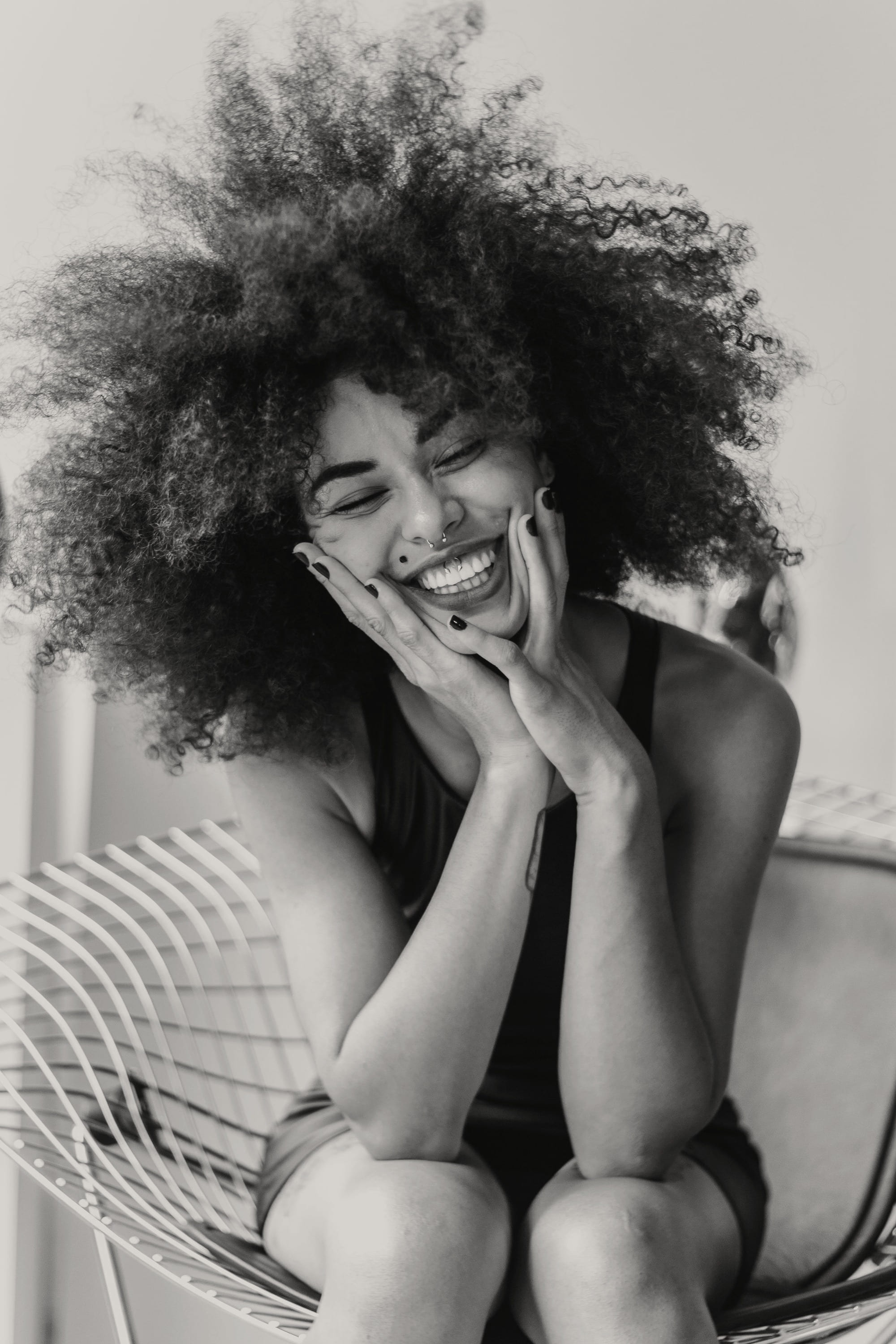 A woman laughing with her hands at her face