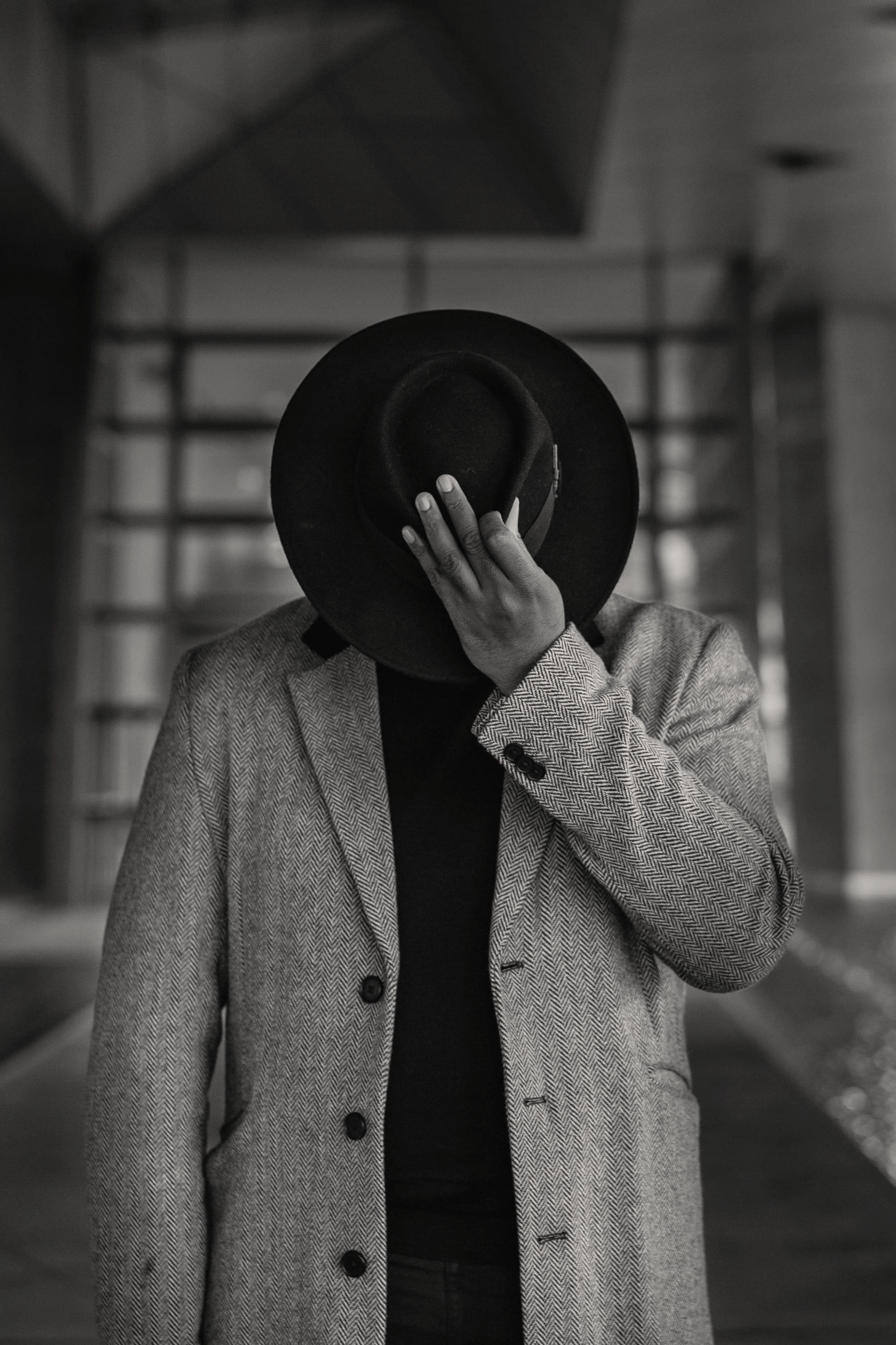A man hiding his face behind his hat