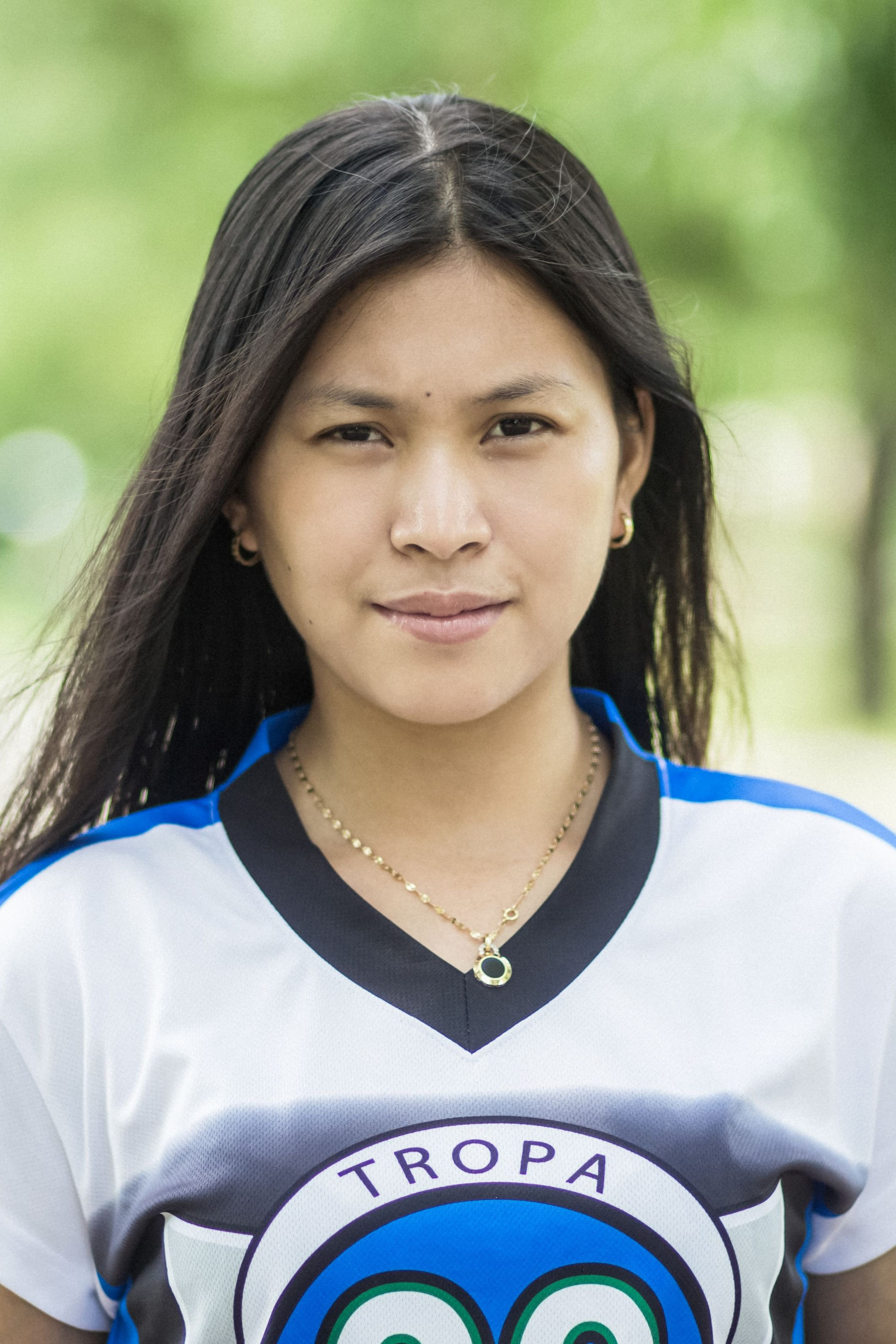 A teenager in a sports jersey, grinning