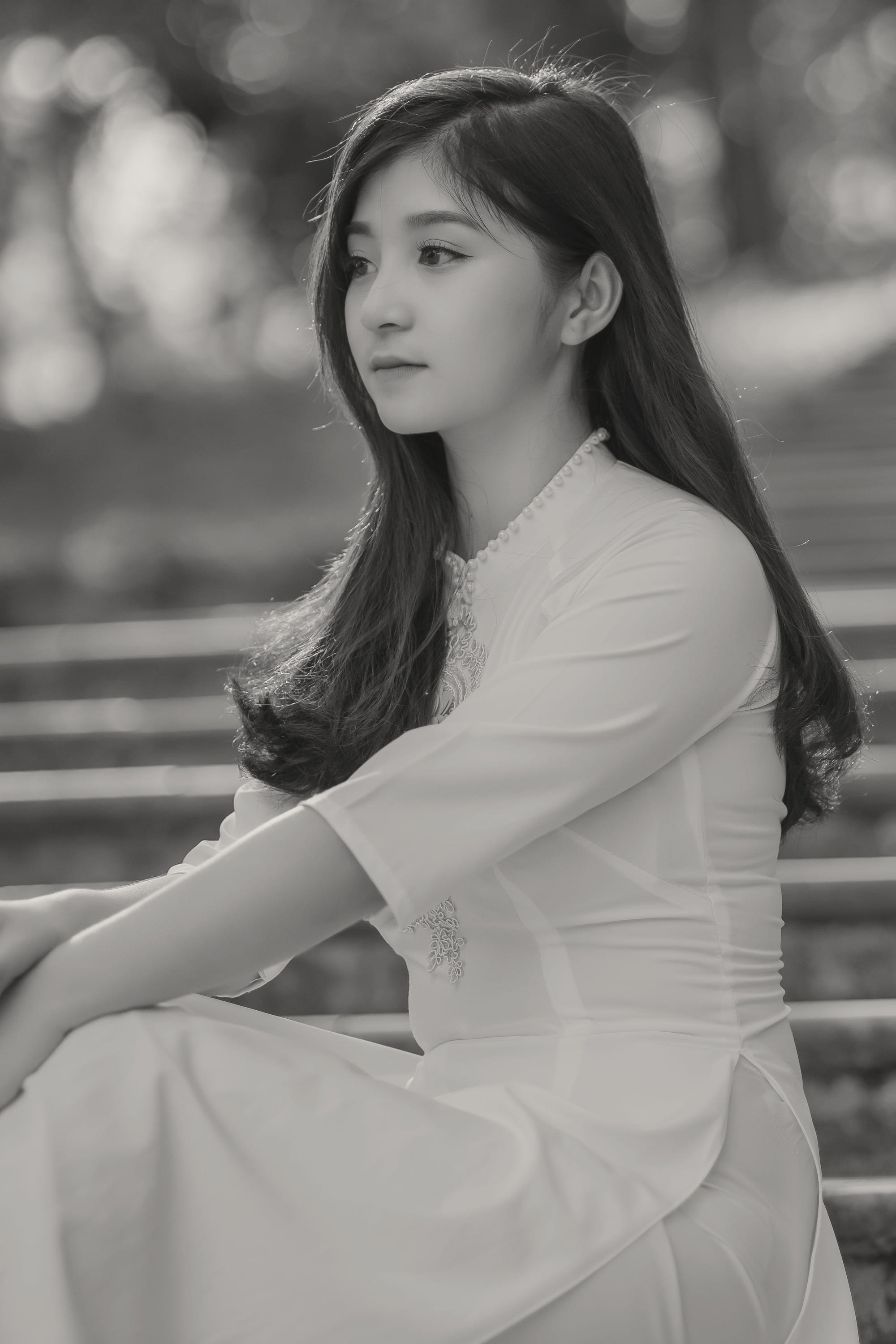 A woman in a white dress seated on stone steps